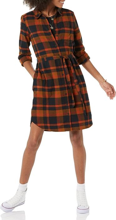 A model wearing the dress in a brown tartan pattern.