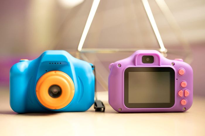 A reviewer's photo showing toy cameras in blue and purple