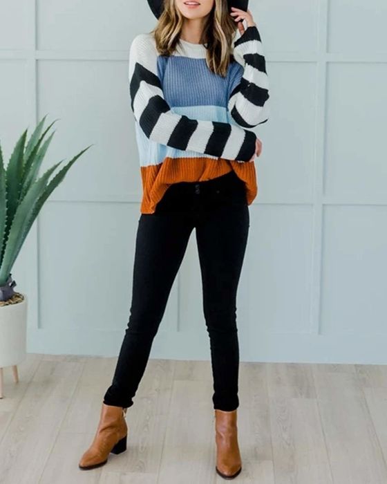 A model showcasing a pullover sweater featuring color blocking and black-and-white striped sleeves