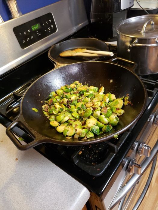 reviewer photo of a wok on the stovetop cooking Brussels sprouts