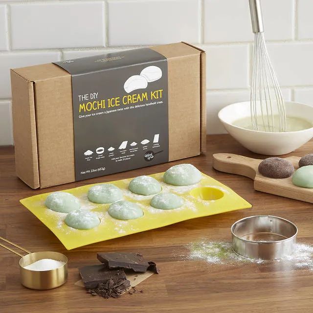 Mochi ice cream pieces inside a silicone mold, accompanied by ingredients and packaging, ready to be made into the perfect chilled treat.