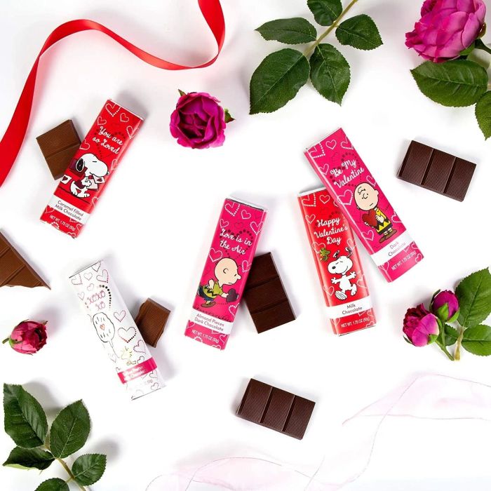 Assorted Peanuts-themed chocolate bars paired with roses, perfect for the peanut-loving sweet tooth in your life.