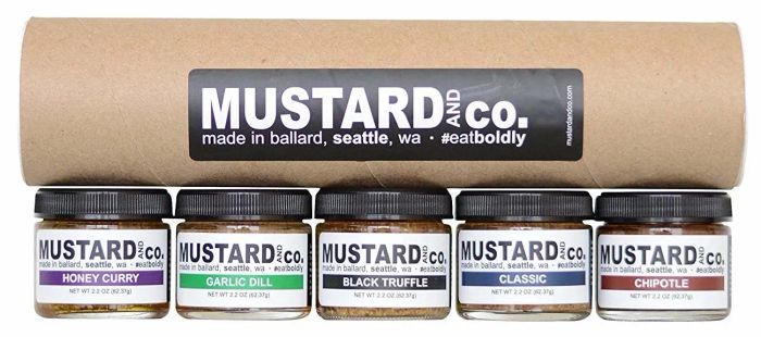 A cardboard tube filled with five mustard sample jars, each offering a unique flavor to elevate their meals.