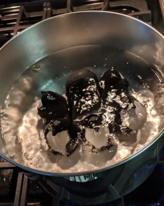 The penguin egg cooker submerged in a pot of boiling water