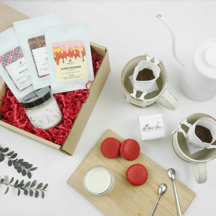 The gift set, featuring coffee packets, a coffee-scented candle, and three red macarons, ready to indulge their senses.