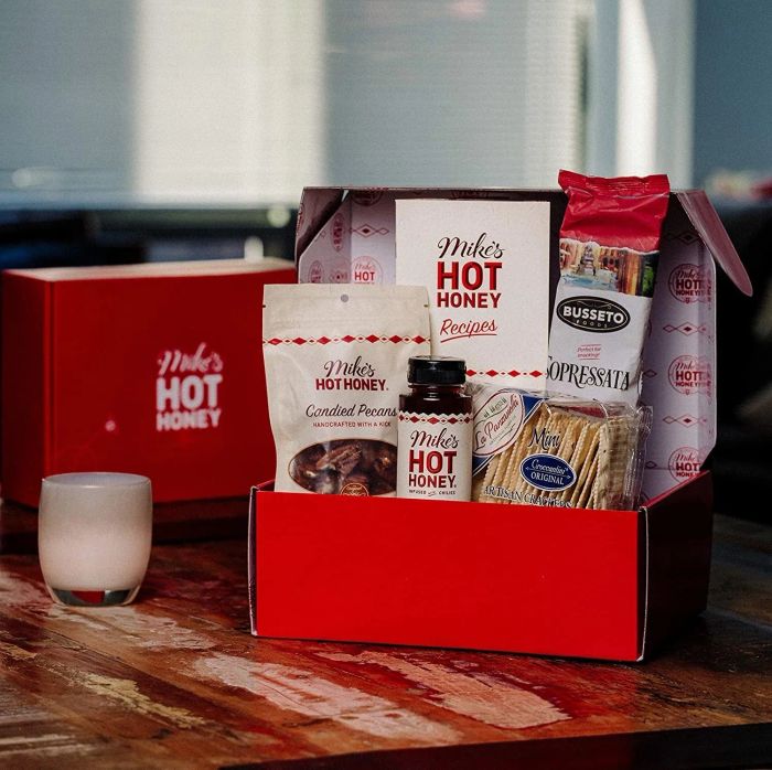 The red gift basket filled with various snacks and a bottle of Mike's Hot Honey.