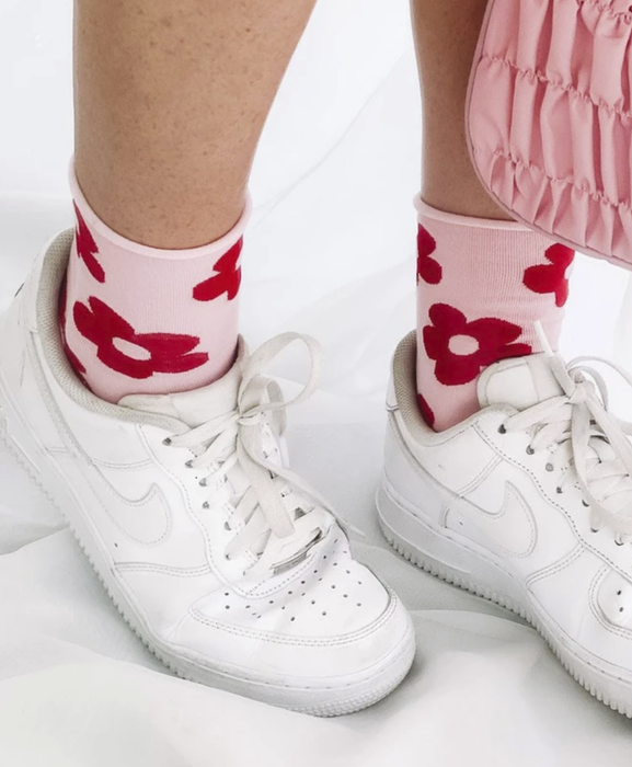 The model's feet are seen wearing the socks paired with low-top Nike Air Force One sneakers.