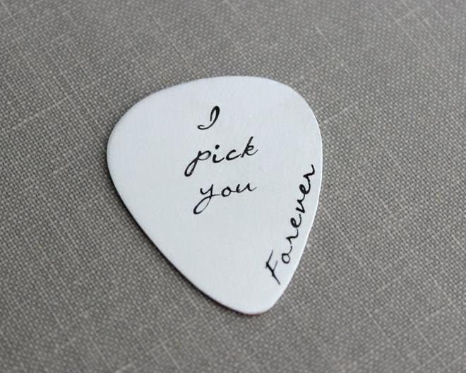 A white guitar pick featuring the engraved phrase 'I pick you forever.' It's a sweet pun—'I PICK you'—perfect for a heartfelt gift.
