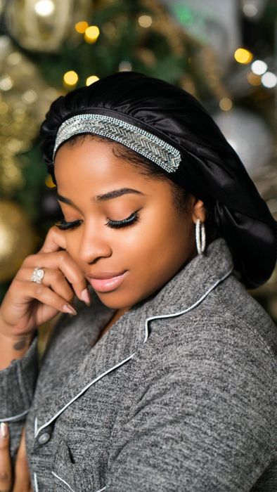 model wearing a black silk bonnet adorned with beads along the brim