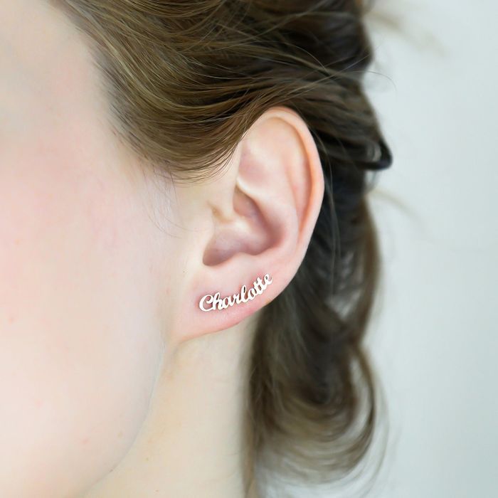 A stud earring that’s delicately shaped to resemble the name 'charlotte' in cursive, fitting perfectly on the lower part of the earlobe.