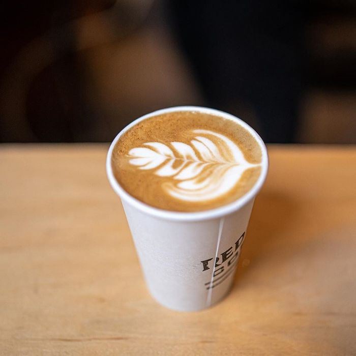 A cup of coffee topped with a frothy layer.