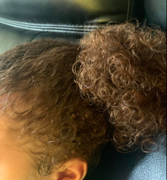 A reviewer's picture of a child's super curly hair.