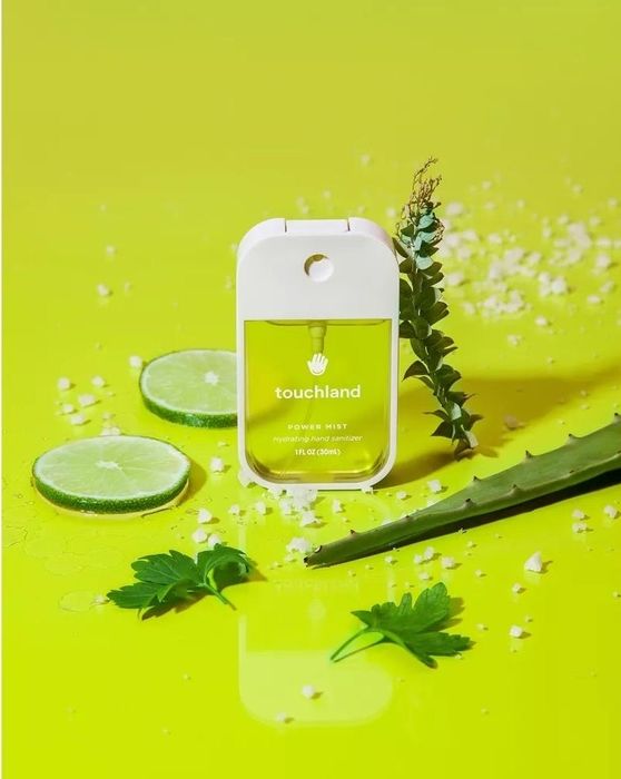 A bright green background with green sanitizer, lime slices, white dots, and leaves