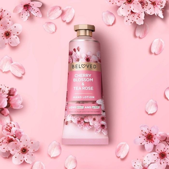 A photo showing pink cherry blossoms with a bottle of lotion in the center