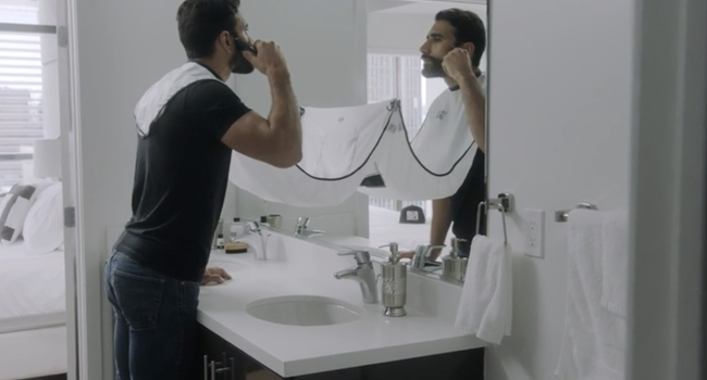 A model trimming their beard above a plastic surface, avoiding any mess from the trimmings.