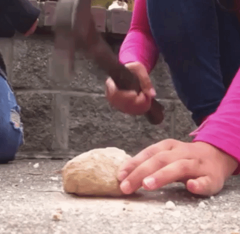 A GIF of someone cracking open a geode with a hammer
