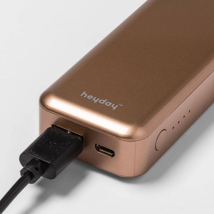 A rose gold phone charger with a black cord