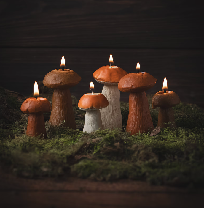 Mushroom-shaped candles rest on a bed of moss, their flickering flames casting a warm, woodland-inspired atmosphere.