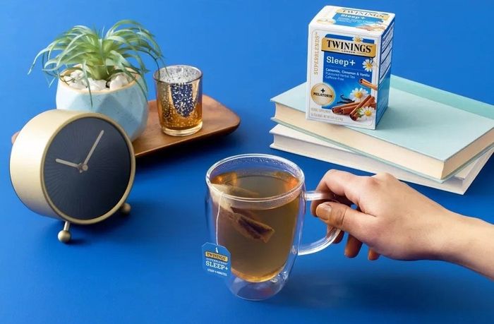A box of tea with a blue background and a steaming cup of tea