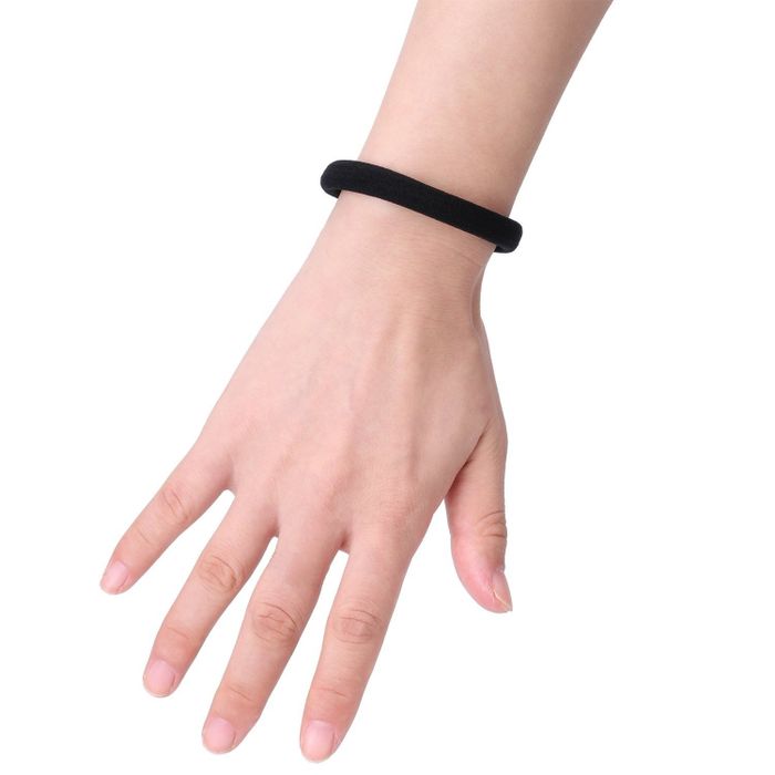 A thick, black hair tie worn on a wrist for a chic and practical look.