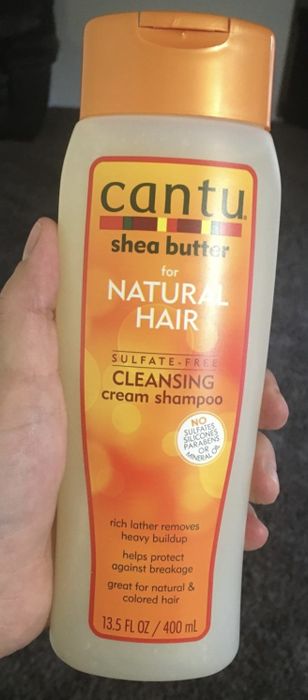 a person holding the shampoo bottle in their hand
