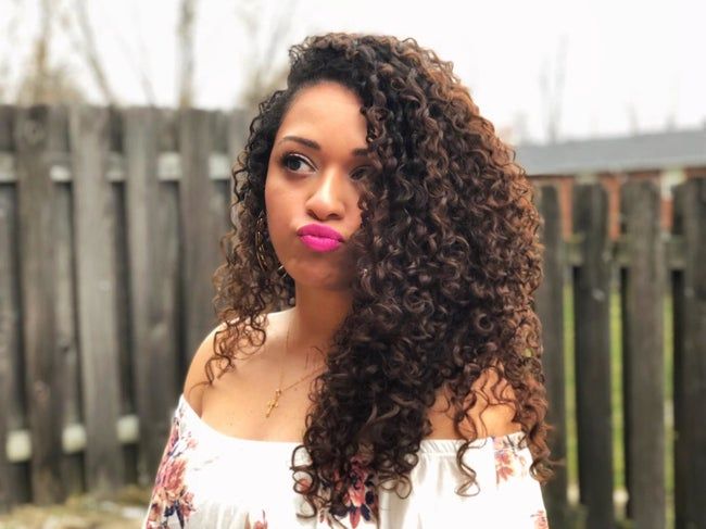 A reviewer showcases their long, defined curls with a beautiful, shiny finish.