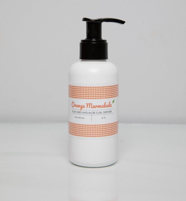 The iconic pump bottle of Ecoslay's Orange Marmalade, ready to define your curls.