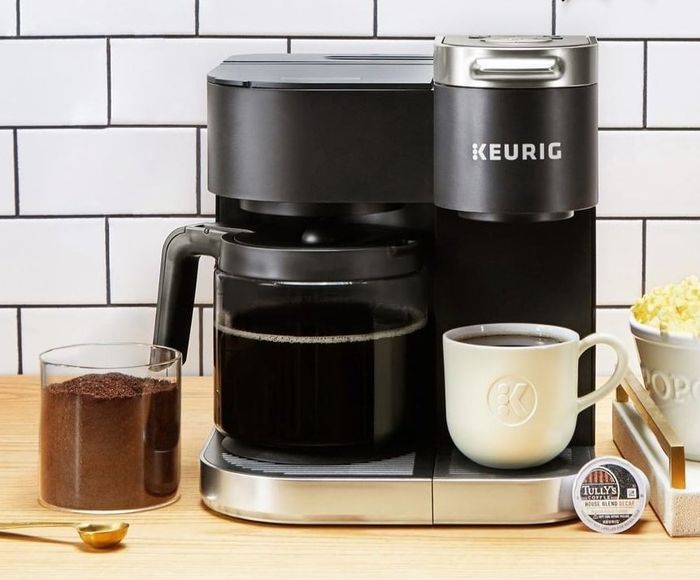 the K-Duo brewer with a full carafe of coffee on one side and a mug of coffee on the other
