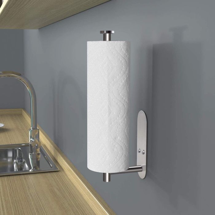 A sleek, modern wall-mounted paper towel holder placed next to a kitchen sink, designed for efficient kitchen organization