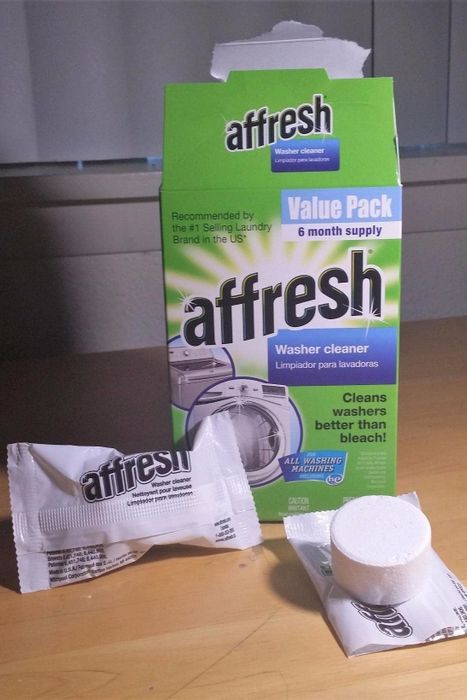 The packaging of Affresh Washing Machine Cleaner Tablets next to an open tablet