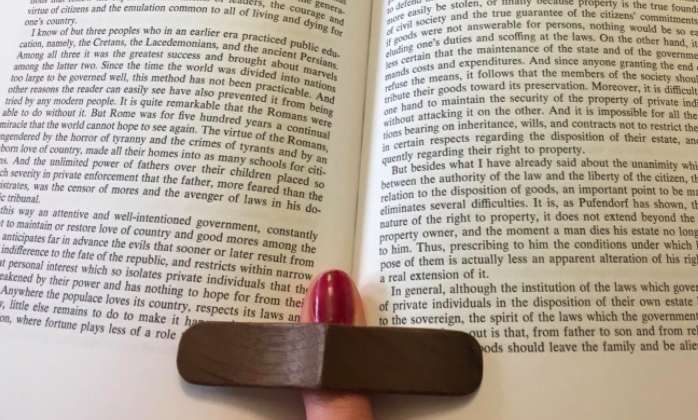 a reviewer using the book page holder to keep their book open while reading