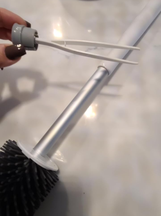 Another reviewer demonstrates the hidden tweezers inside the handle of the toilet brush.