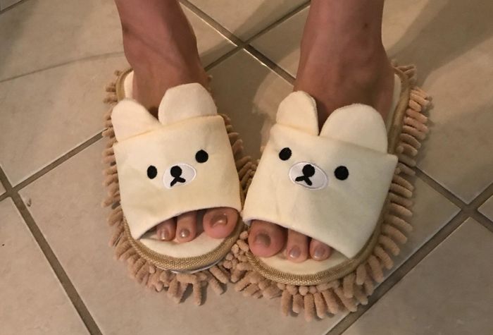 a reviewer showcasing a pair of teddy bear mop slippers