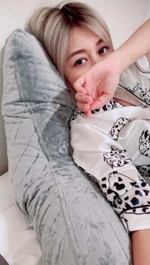 a reviewer leaning against the pillow in their bed