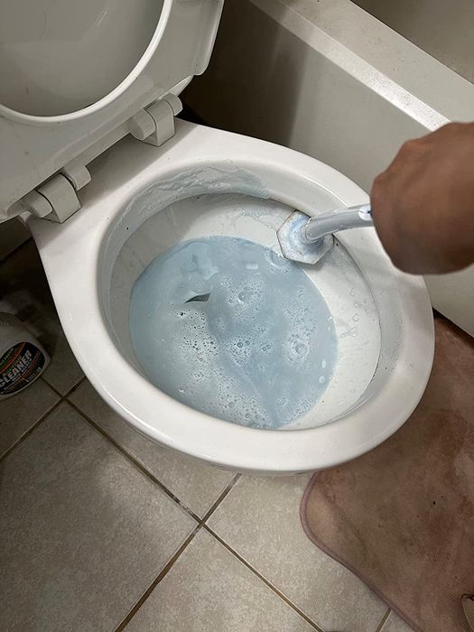 A reviewer using the Clorox wand to clean their toilet.
