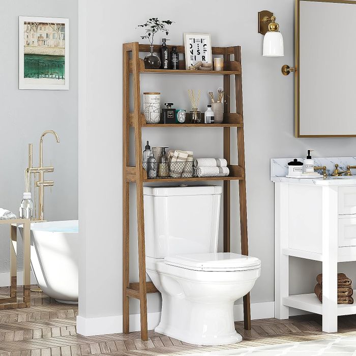 A photo of the light brown, three-tier shelf placed above a toilet.