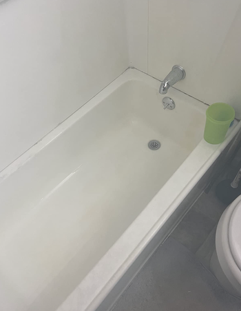 the same bathtub now spotless after applying The Pink Stuff
