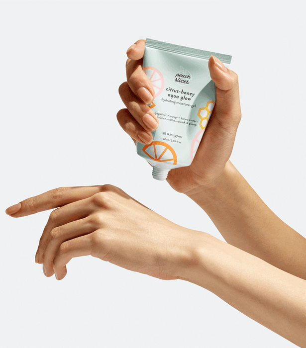 A gif showcasing a model gently squeezing moisturizer from the bottle and applying it to their hand.