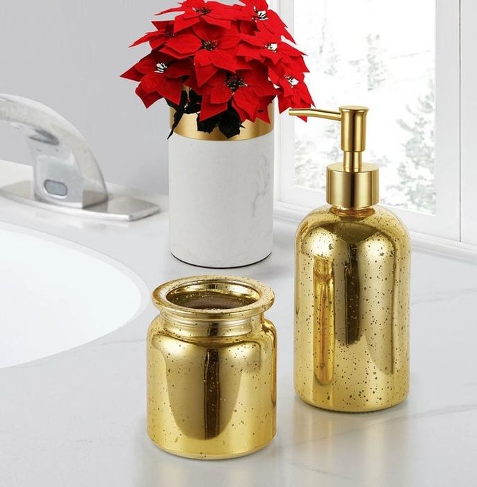 gold soap dispenser and toothbrush holder set elegantly placed on a marble bathroom counter