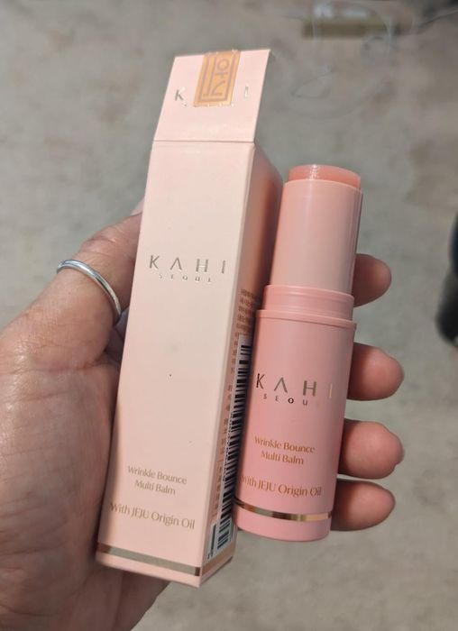 A hand holds the Kahi Seoul Wrinkle Bounce Multi Balm along with its packaging.