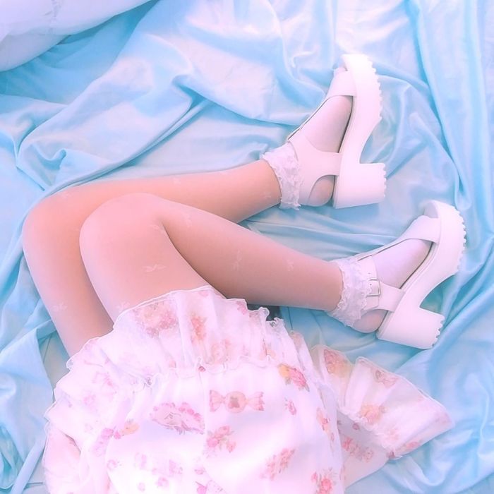 A reviewer wearing the platform sandals in white with lace socks and a dress.