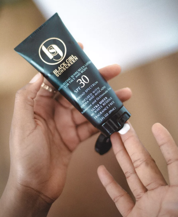 Hands applying sunscreen from the tube