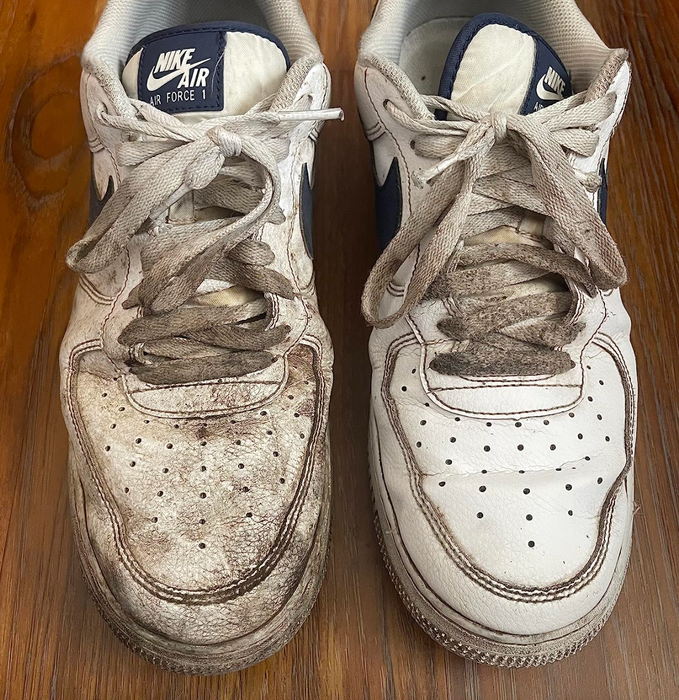 A pair of sneakers, with one side dirty and the other side cleaned using the SneakEraser.
