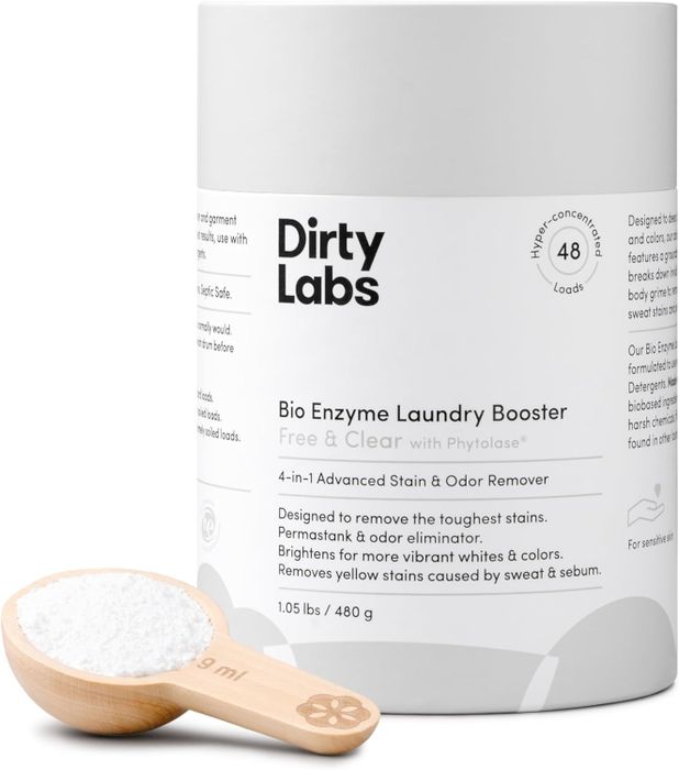 Dirty Labs Bio Enzyme Laundry Booster with a wooden scoop. The label emphasizes its ability to remove stains and odors, brighten clothes, and provide eco-friendly benefits.