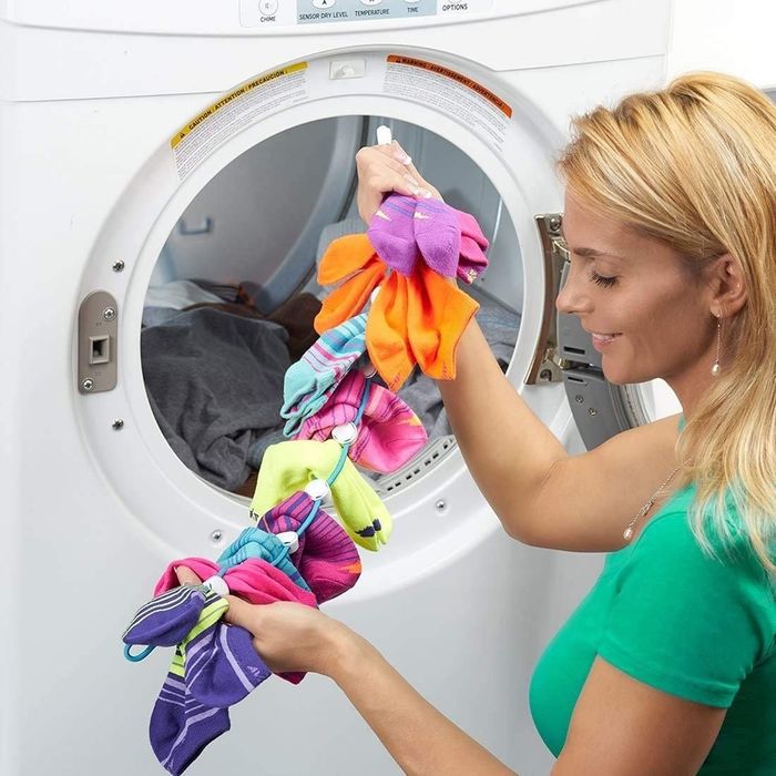A person taking the SockDock out of the dryer, with all socks neatly paired and fresh.