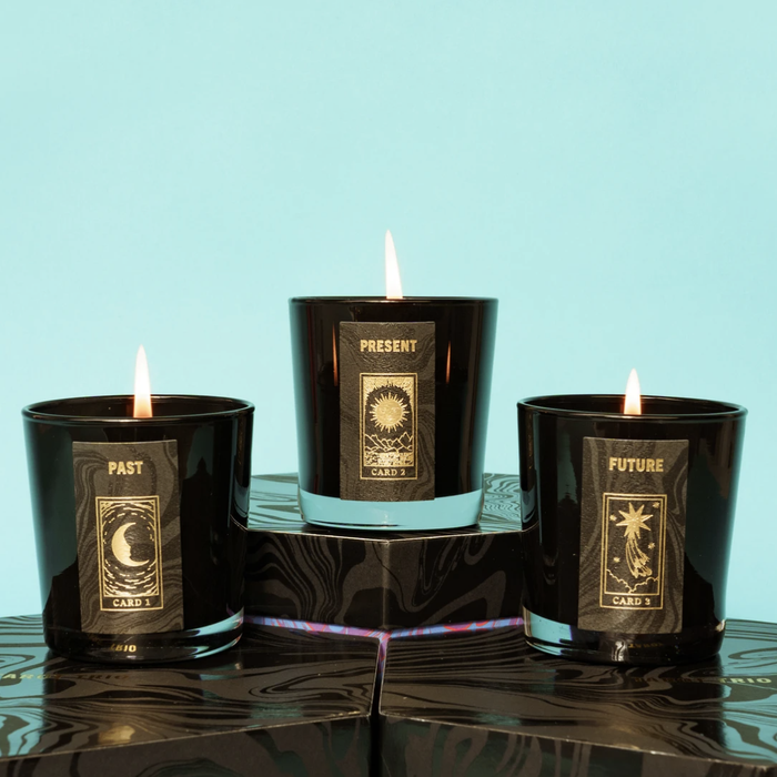 A close-up view of the past, present, and future candles, all lit and glowing.