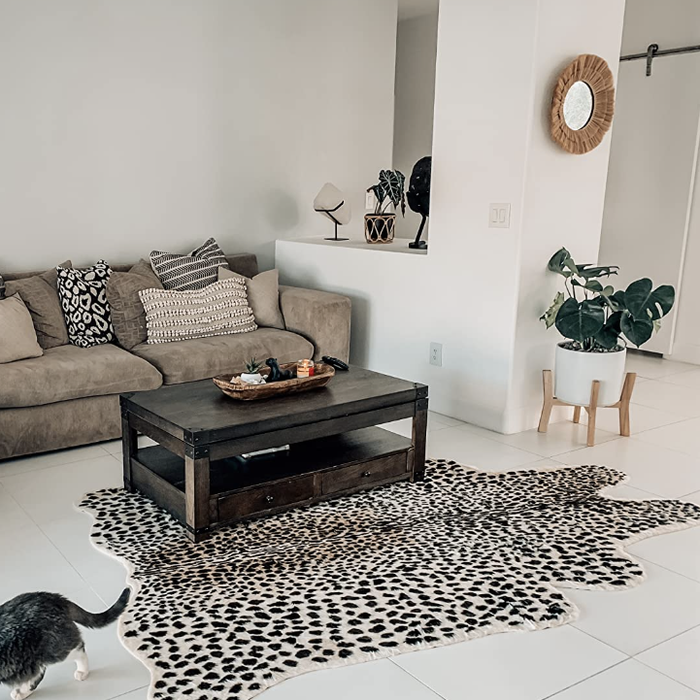 The reviewer's bold leopard print faux hide rug contrasts beautifully in their minimalist living room.