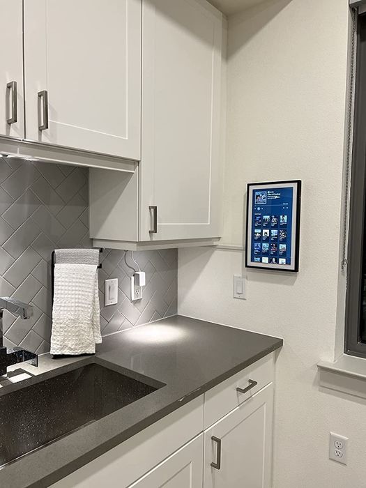 The reviewer's tablet is displayed mounted on their kitchen wall for easy access and convenience.
