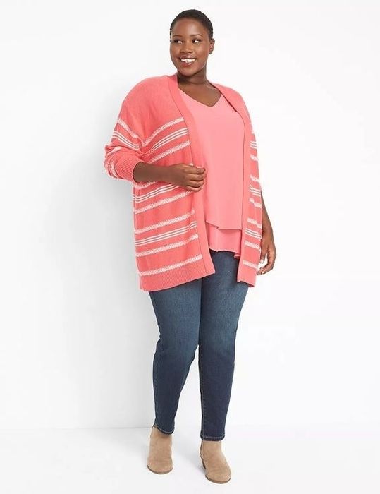 The model is wearing a pink tank underneath a cozy sweater
