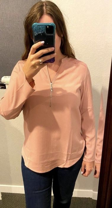 A selfie from the reviewer wearing the soft light pink top